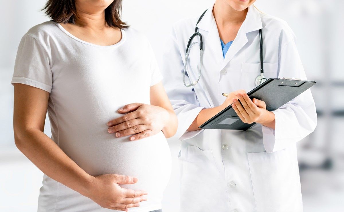 trudnica u beloj majci poerd koje stoji lekar