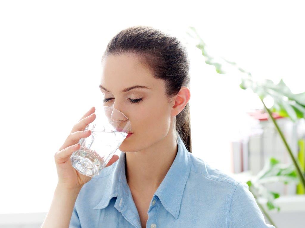 žena koja pije vodu iz čaše