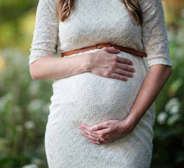 trudnica drži ruke na stomaku
