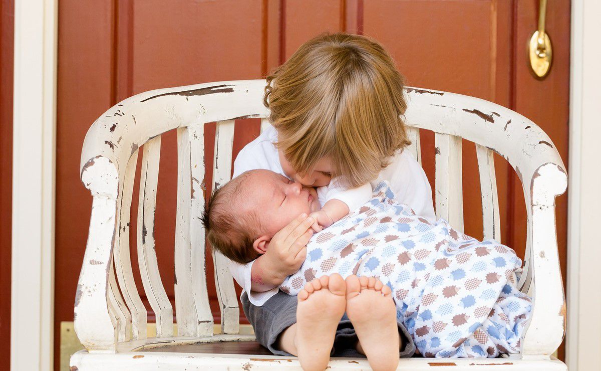 dete drži bebu u naručju